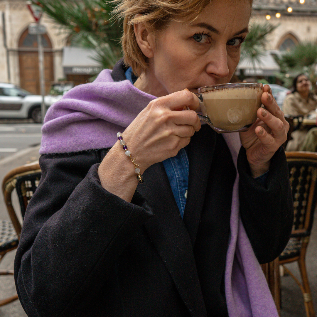 Bracelet amincissant composé d'améthyste et de pierre de lune qui alternent avec de petites billes en or fin entre elles, avec une seule pierre de quartz rutile en son centre, entourée d'un anneau en or fin