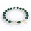 Bracelet avec des pierres de malachite brute qui alternent avec de petites billes en or, avec une seule pierre de quartz rutile en son centre, entourée d'un anneau en or. Le bracelet est composé de malachite et d'or fin.